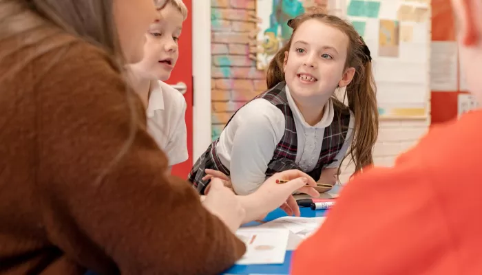 A pupil is smiling and looking eagerly at the tutor during a tuition session.