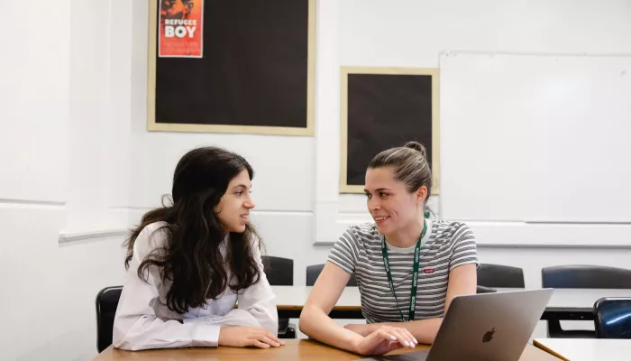 A tutor and a pupil smile during a tuition session.