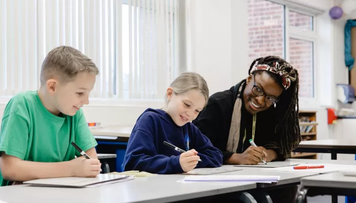 A tutor supports two young pupils