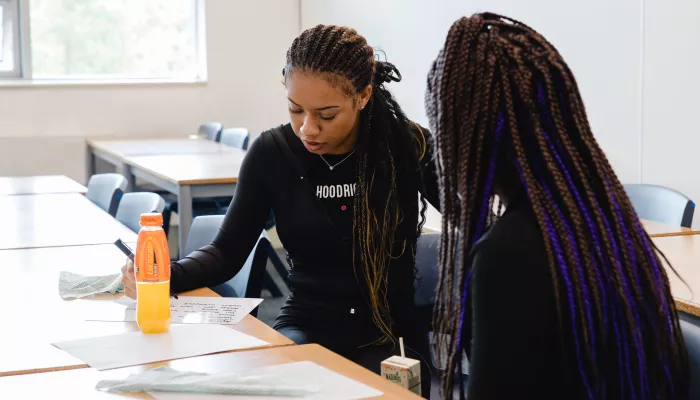 A student sits at a desk with a tutor 