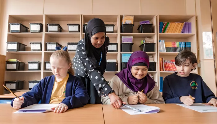 A tutor supports two Year 5 pupils with their Maths.