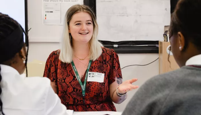 A tutor smiles at two tutees