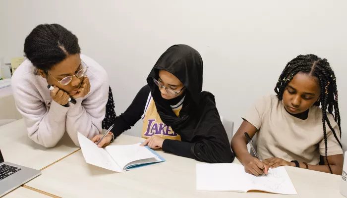 A tutor supports two young pupils with their Maths