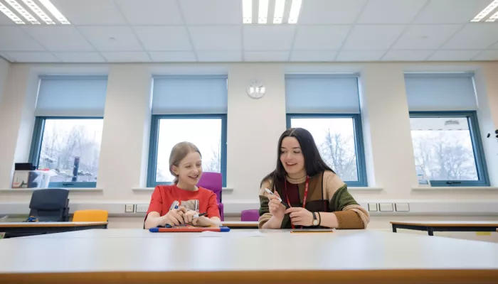 A tutor and tutee sit side-by-side