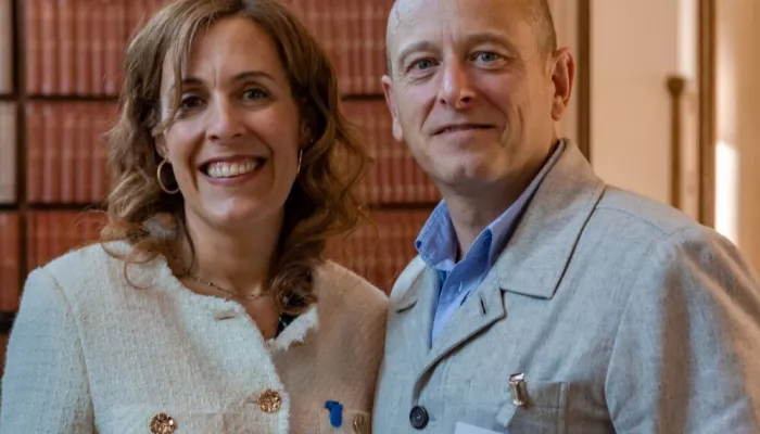 Abigail Shapiro from Tutor Trust wears a white jacket and stands alongside Adam Waller from PwC who wears a blue shirt and grey jacket 