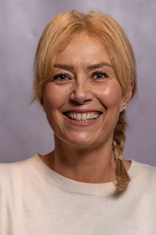 Sharon Sadler is West Yorkshire Schools Partnership Manager. She believes passionately in the power of education to transform lives. Sharon is pictured in a white top. She has shoulder length auburn hair, tied in a plait.  