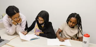 A tutor supports two young pupils with their Maths