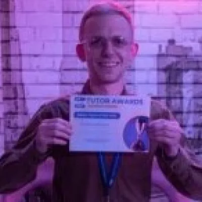 A man in glasses holds a winner's certificate