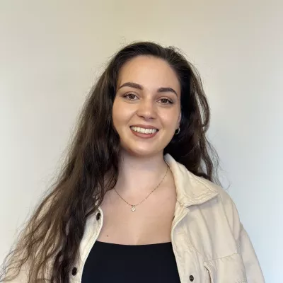 Hannah Cunningham is a former teacher who enjoys making a positive impact on young people's lives.  Hannah has long brown hair and is wearing a black jumper.