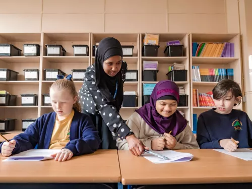 A tutor supports two young Year 5 tutors with their Maths.