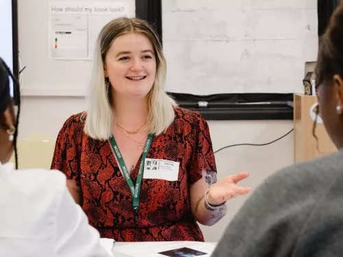 A tutor smiles at two tutees