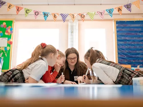 Pupils are enthusiastically leaning in to see the tutor's work. 