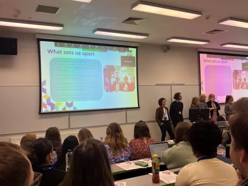 A Tutor Trust team presenting at the front of a busy lecture theatre