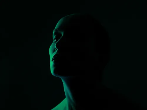 silhouette of a woman's head in low green light